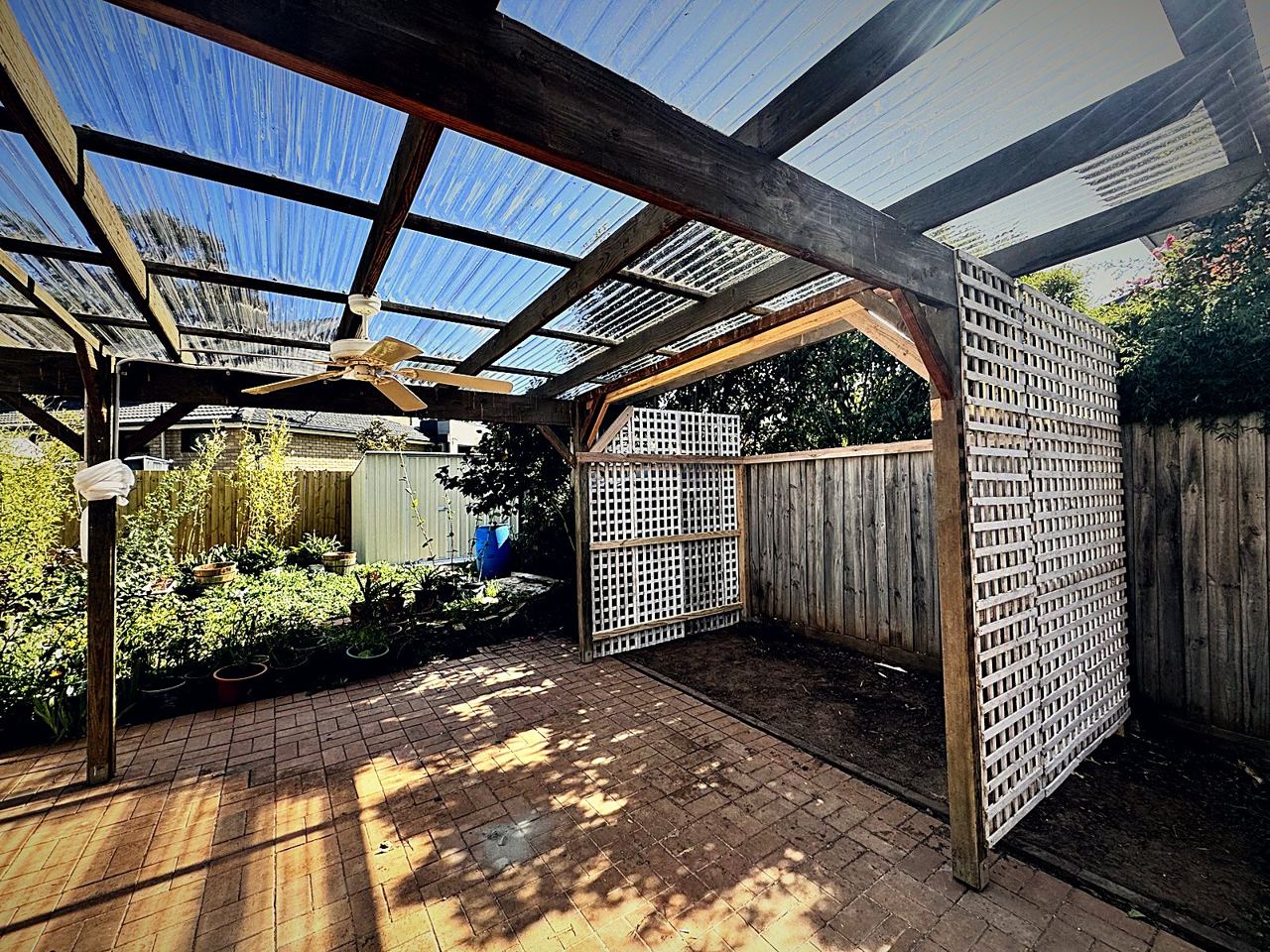 Finished pergola over a brick-paved courtyard